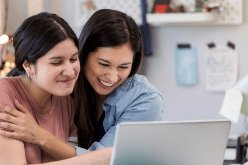 Daughter and mother celebrating over a computer