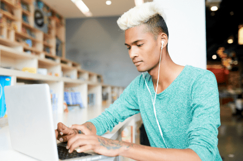 Student with bleached mohawk typing on laptop
